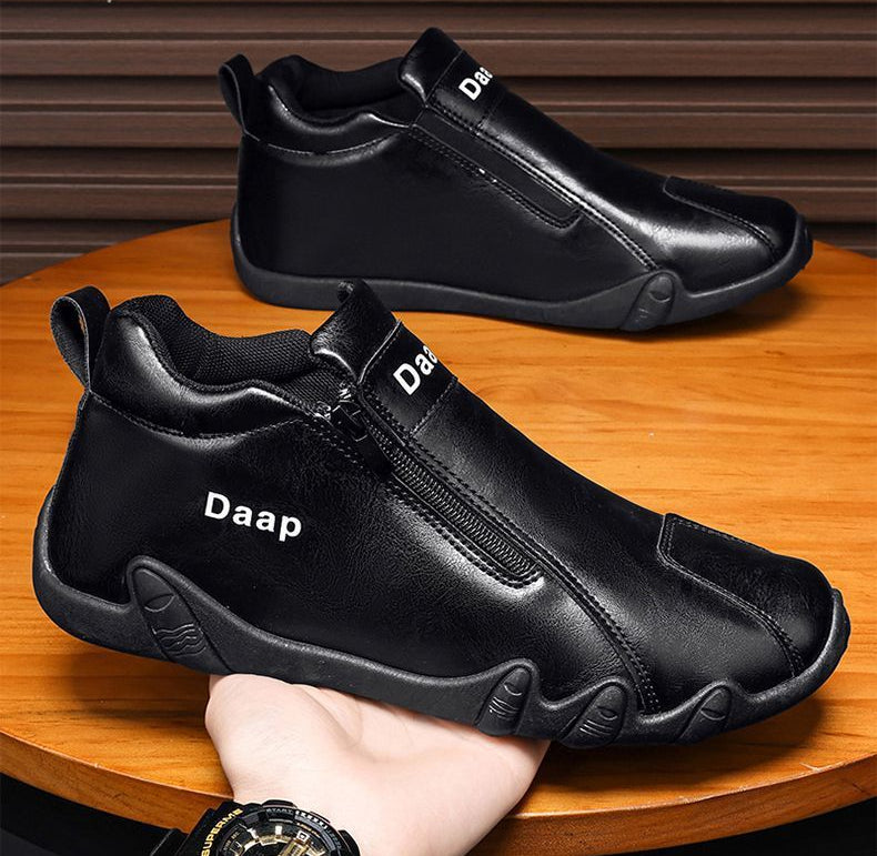 Black shoes with 'Daap' branding on a wooden surface