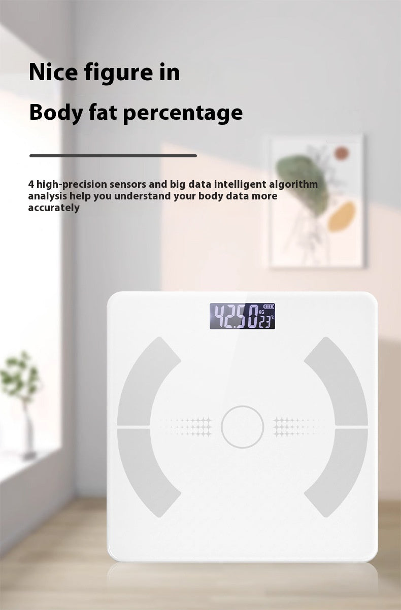 A white digital body fat percentage scale is shown in a bright, modern room setting. The scale features a digital display showing '42.