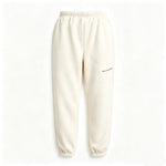 Cream-colored fleece jogger pants with an elastic waistband and cuffs, featuring a small diagonal zip pocket on the left thigh.