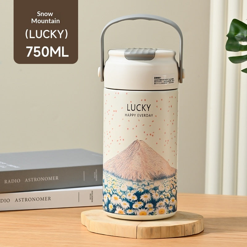 Thermos with Mount Fuji design on a wooden surface with books in the background