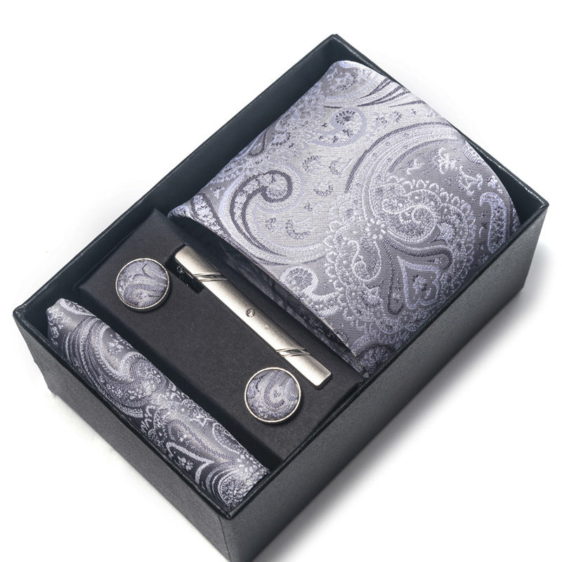 Paisley patterned tie set with tie clip and cufflinks in a black box on a white background