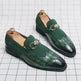 Green loafers with gold buckles on a grid background