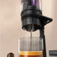 Coffee being poured from a coffee maker into a glass container with a beige background.