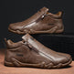 Brown leather shoes with zippers on a dark background
