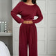 Person wearing a burgundy outfit in a room with a mirror and candles.