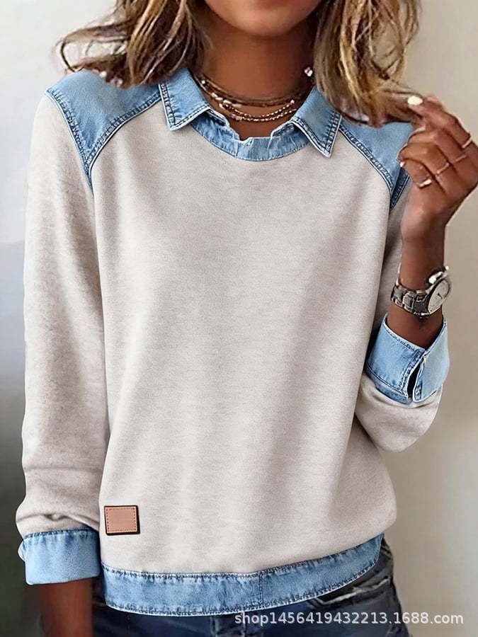 Light-colored sweatshirt with denim collar and cuffs worn by a person.
