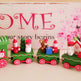 Decorative Christmas train set with Santa Claus figures on a wooden surface.