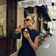Woman in a polka dot dress eating ice cream outside a restaurant.