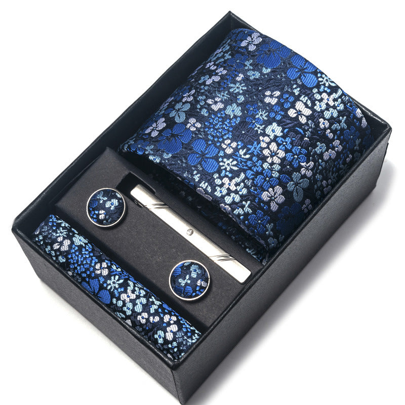 Blue floral tie set with tie, pocket square, and cufflinks in a black box on a white background