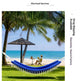 A blue and white woven hammock strung between palm trees on a grassy lawn, with a beach, ocean, and seated person visible in the background. Text on the right reads 'Drop Shipping Electricity-Source Factory' and 'Merchant Services' appears at the top.
