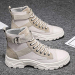 Pair of beige and white high-top boots on a dark textured surface