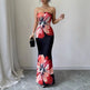 Woman wearing a strapless dress with floral design in a room with white walls and gray floor.