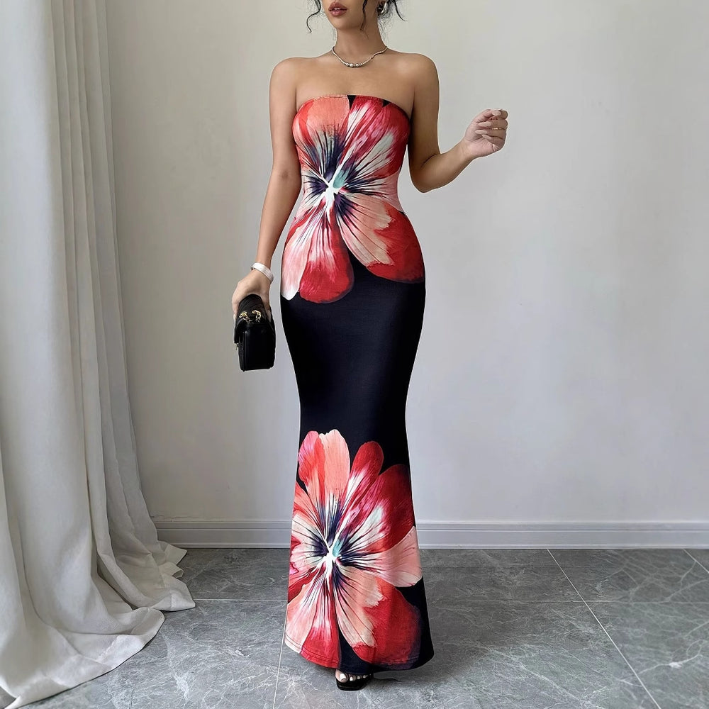 Woman wearing a strapless dress with floral design in a room with white walls and gray floor.