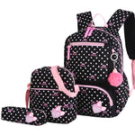 Black polka dot backpack with pink accents and a matching pouch on a white background