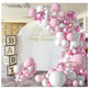 Pink, white, and silver balloon garland arch decoration with a large white round backdrop featuring gold script text reading 'Welcome to Jerris-Leger Baby Shower,' plus stacked wooden baby blocks on the left.