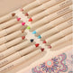 Set of Handanyan eyeshadow pencils with colorful caps on a decorative mat.