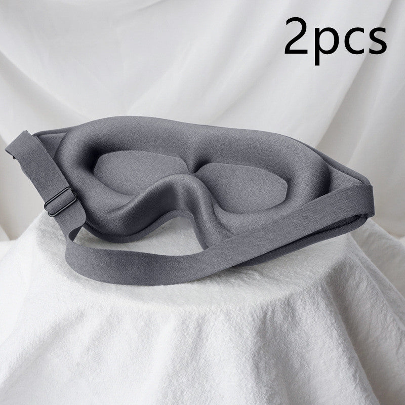 Gray sleep mask on a white fabric background with '2pcs' text.