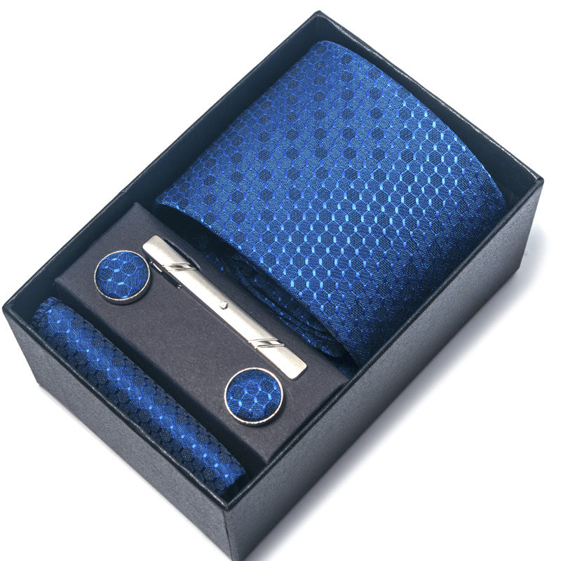 Blue tie set with tie clip, cufflinks, and pocket square in a black box on a white background