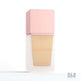 Foundation bottle with pink cap and beige shade on a white background