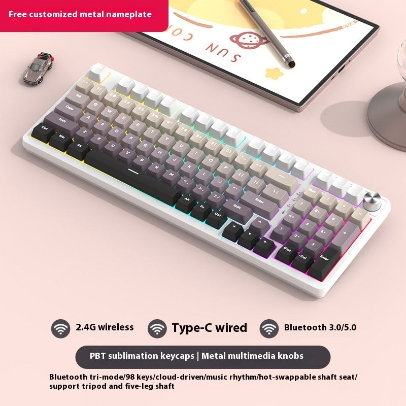 Mechanical keyboard with gradient keycaps on a light pink surface, tablet, and small car in the background.