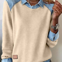 Beige sweater with denim collar and cuffs worn by a person.