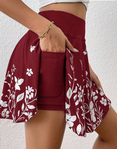 Maroon skirt with white floral pattern worn by a person against a white background