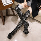 Person wearing black sequin knee-high boots sitting on a couch.