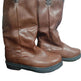 Pair of brown leather boots on a colorful surface with a blurred background