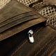 Close-up of a brown leather wallet with a zipper on a textured background