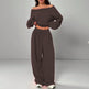 Brown off-shoulder top and wide-leg pants set on a gray background