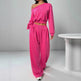 Person wearing a bright pink off-shoulder top and high-waisted pants in a minimalistic setting.