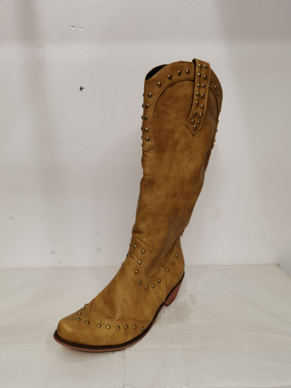 Brown knee-high boot with studded details on a white background