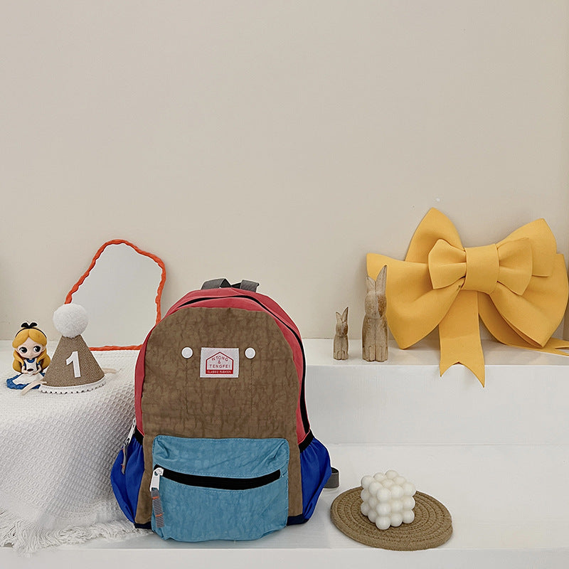 Multicolored backpack with decorative items on a white surface