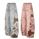 Two pairs of sweatpants with leopard print accents on a white background
