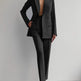 Person wearing a black suit with a white background