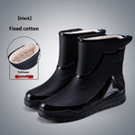 Black rain boots with white lining on a gray background