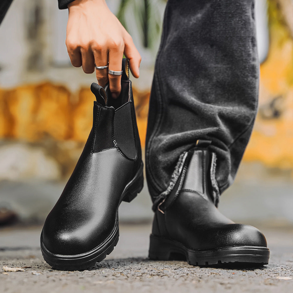 Person wearing black Chelsea boots with a blurred background
