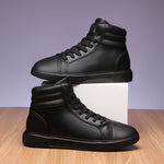 Pair of black high-top sneakers on a wooden surface with a light purple background