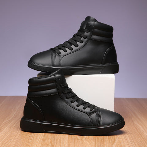 Pair of black high-top sneakers on a wooden surface with a light purple background