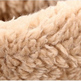 Close-up of a soft, plush fleece fabric in a warm beige or cream color, showing the textured looped pile.