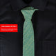 Green tie on a black suit with an item number label.