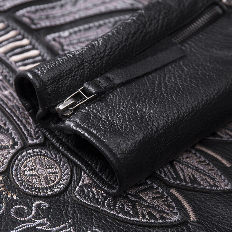 Close-up of black leather glove with zipper on an embroidered background