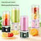 Set of colorful portable blenders with fruits and lemons on a light green background