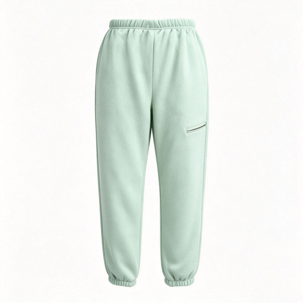 A pair of light mint green sweatpants with an elastic waistband and ankle cuffs, featuring a zippered pocket on the left thigh, shown against a plain white background.