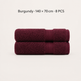 Two folded burgundy towels stacked horizontally on a light off-white background, with text above reading 'Burgundy × 140 × 70 cm · 8 PCS'.